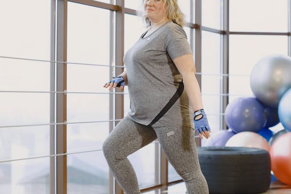 Smiling person standing in a park after a light cardio session.